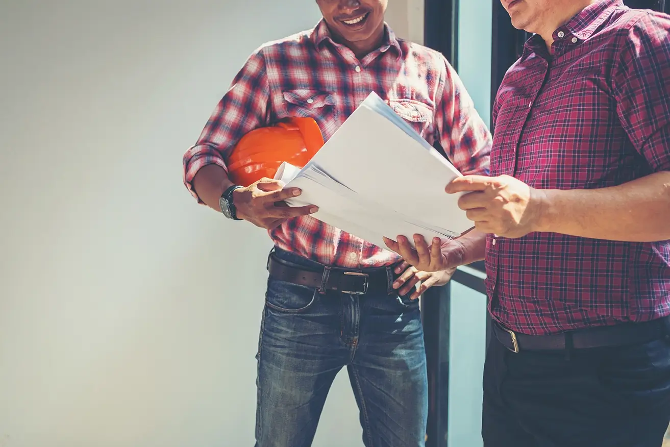 Two roofing contractors meeting to discuss storm damage repair