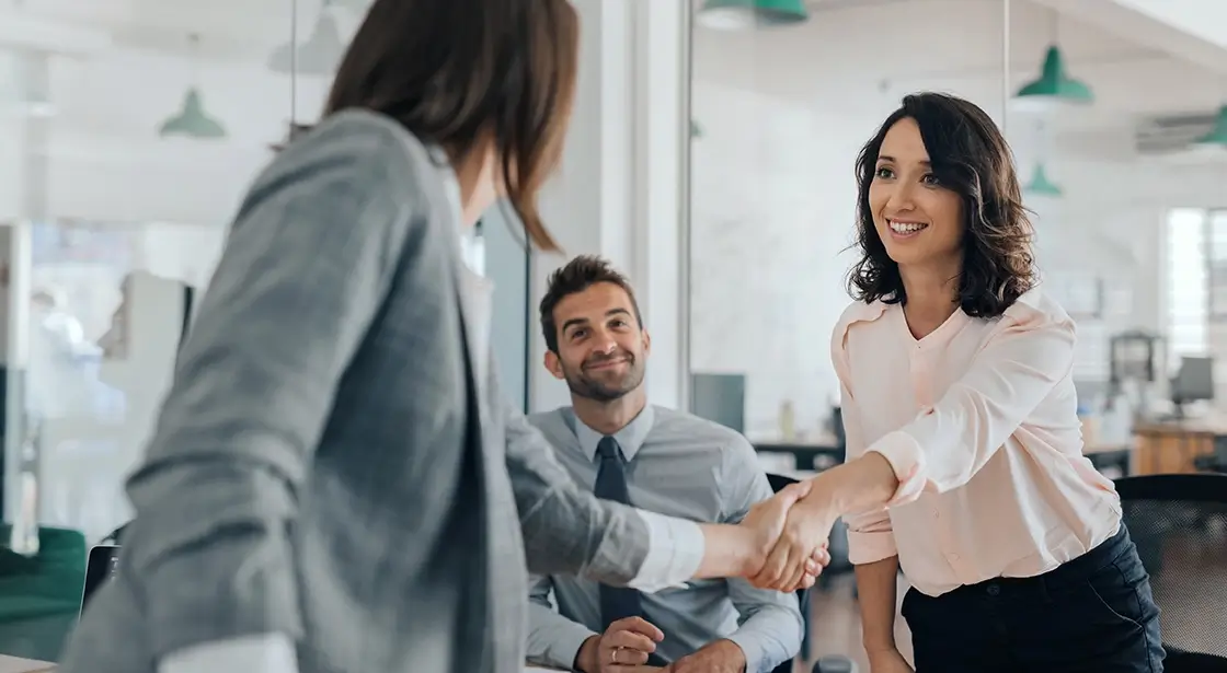 Two business owners shaking hands in commercial building