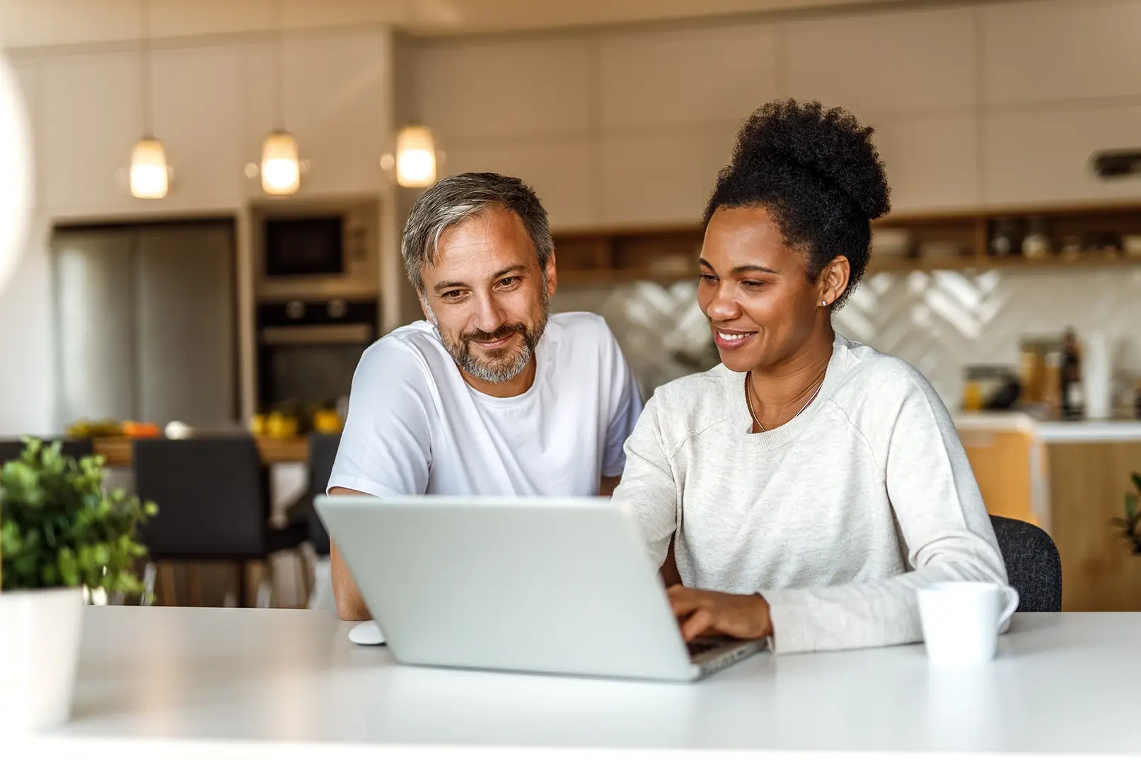 Younger homeowners research roof financing on computer