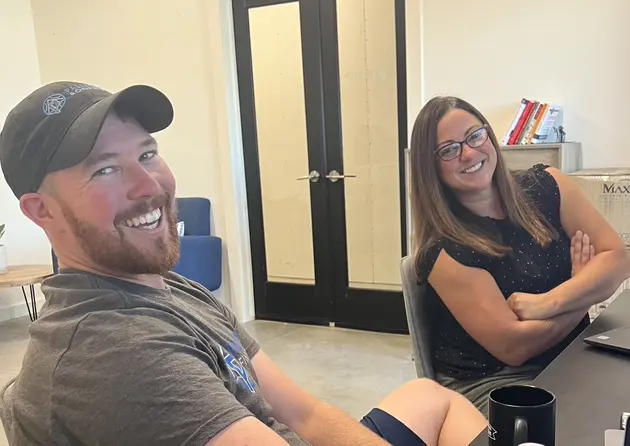 two palladium roofing team members smiling in their office