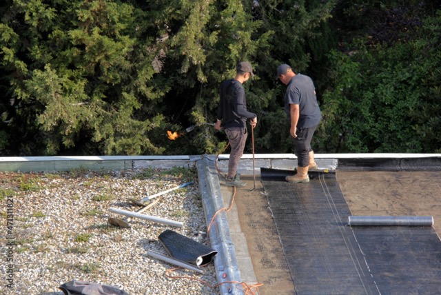 working-on-tar-and-gravel-roof roofing