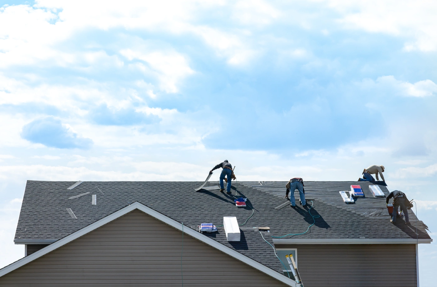 Roofing contractors work to install new shingle roof on Oklahoma home
