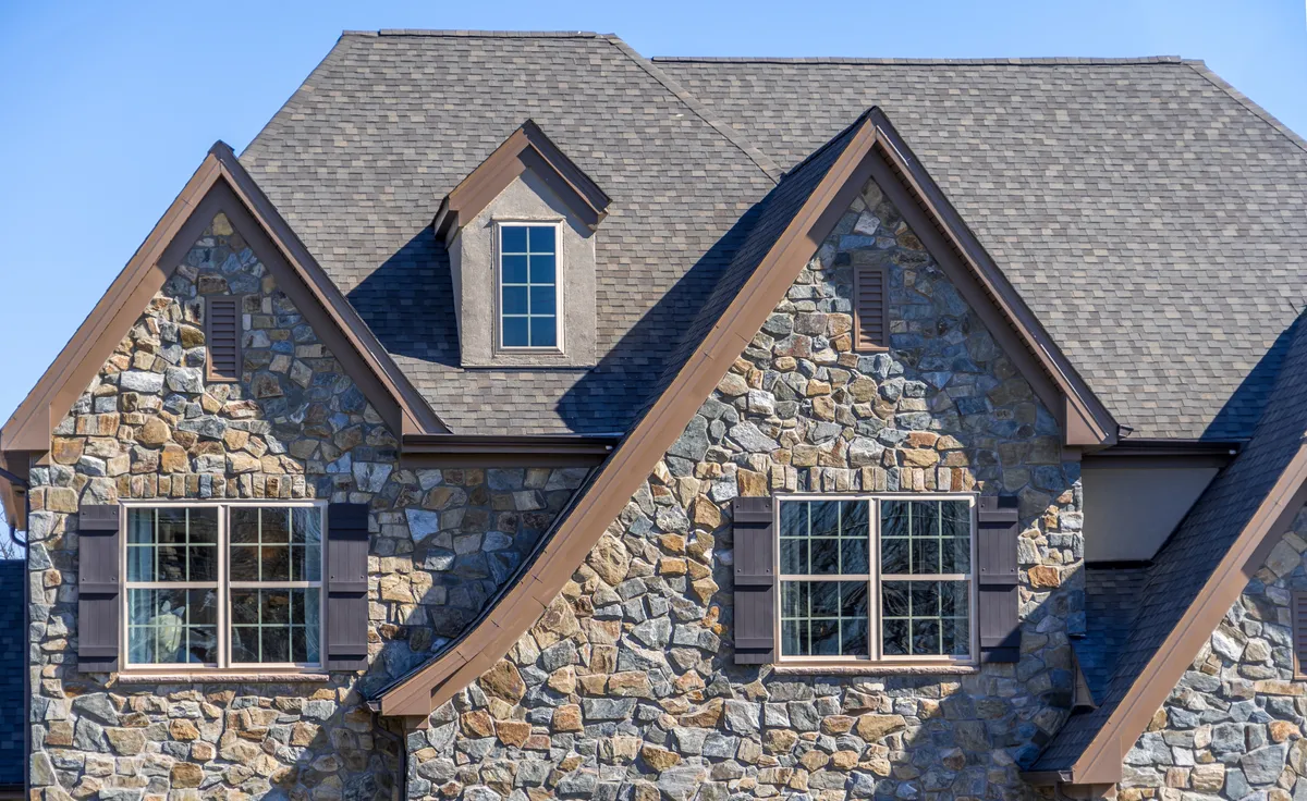 residential home in oklahoma with stone siding and sloped roof eaves