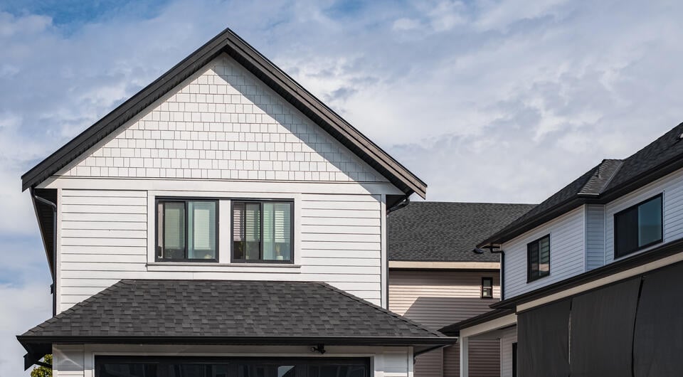 black roof shingles-white sided home with black shingle roof