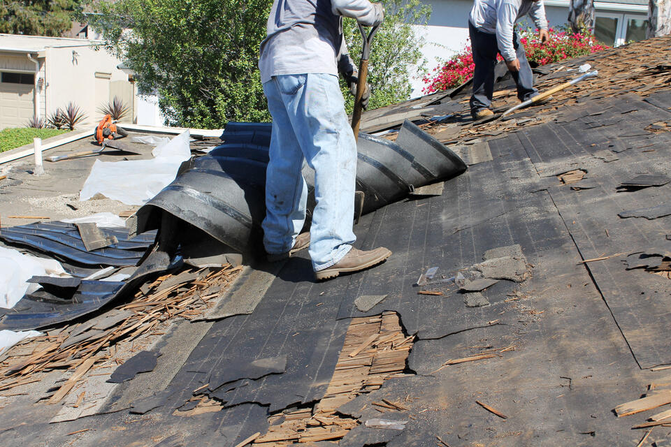 repair or replace roof-roofing crew removing old roofing for a roof replacement