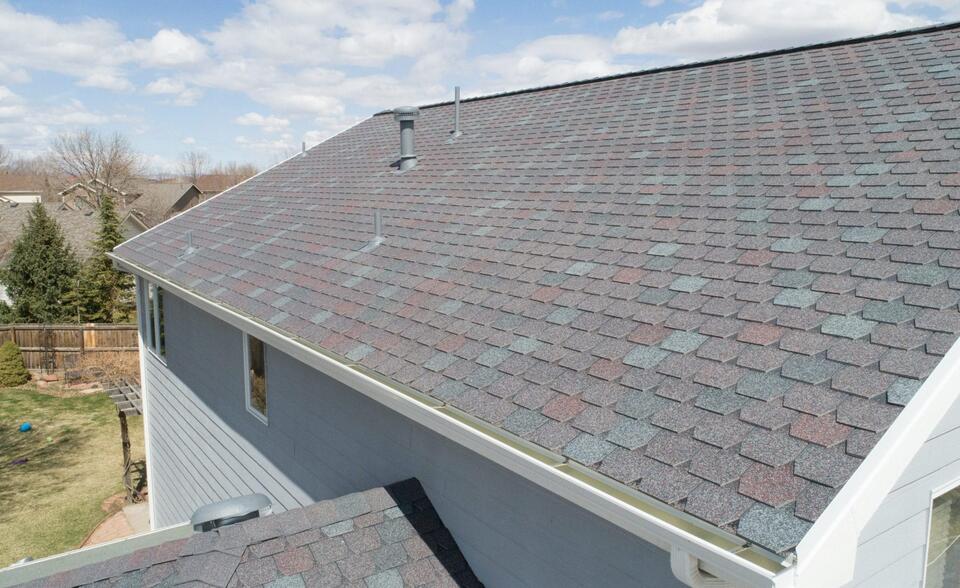 f wave shingles cost-close up of gray shingles on gray sided house