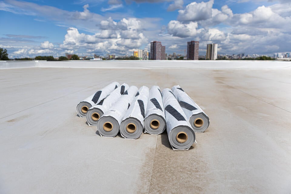 roof membrane-rolls of white pvc membrane on commercial flat roof for installation