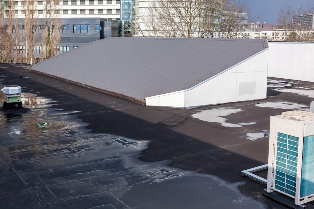 black flat roof signs of leak pooling water