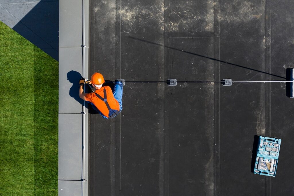 roofer installing black rubber roofing