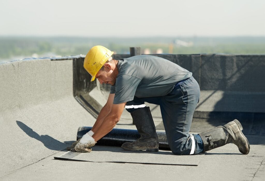 roofer repairing flat roof leak