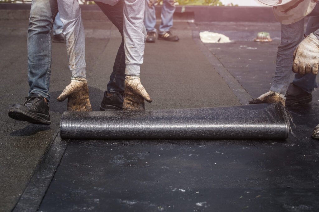 workers repairing flat roof damage