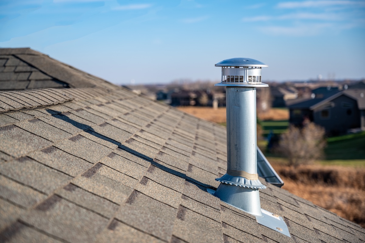 Typical rooftop chimney with a rain cap and shielding