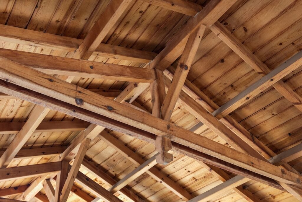 Roof overlap. Roof structure from the inside. Wooden beams, rafters and joists. rafters vs trusses