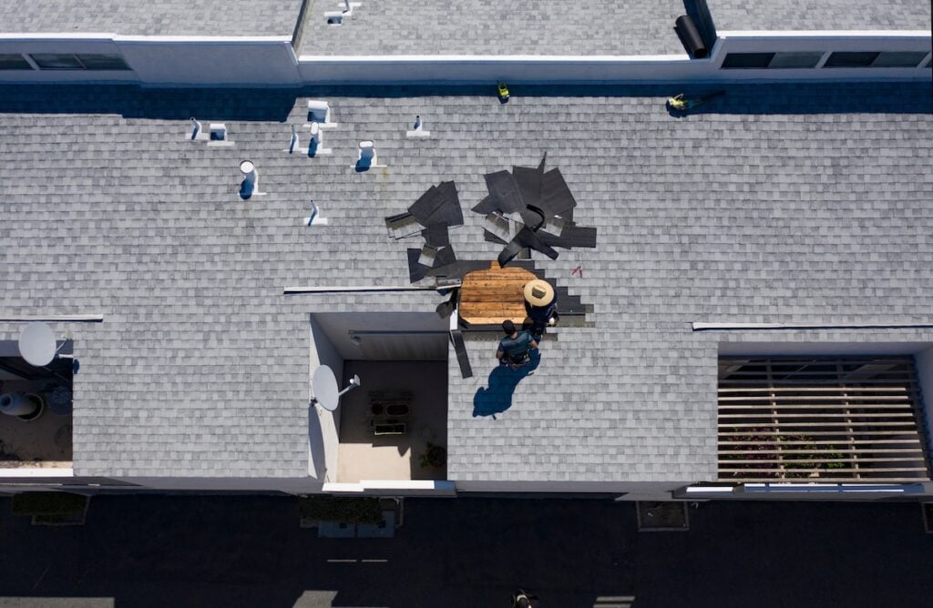 Roof repair,Construction worker using nail gun to install new roof on top roof,Residential building under construction concept roofing companies midwest city