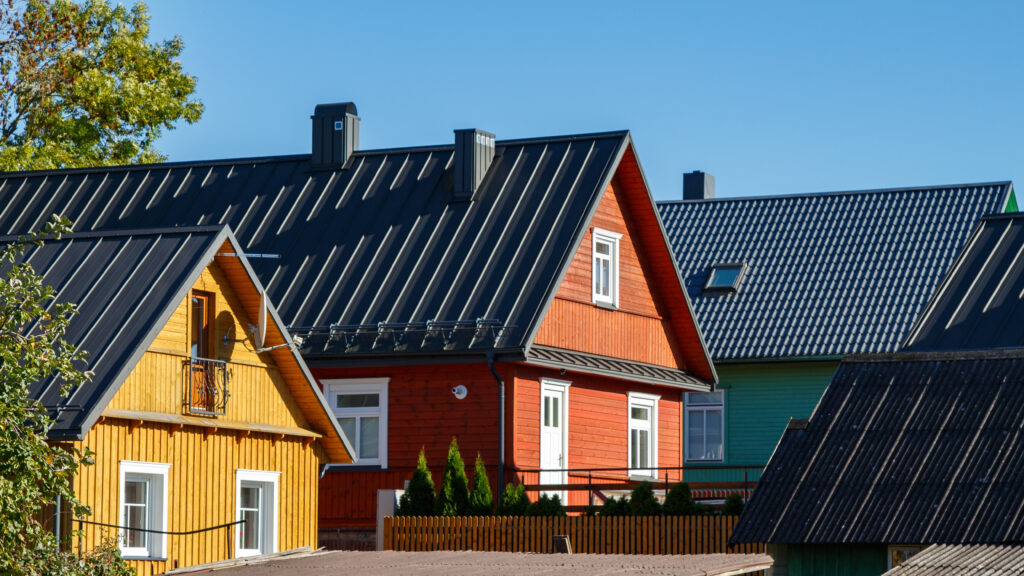 Wooden houses. Classic metal roof. Colorful Houses