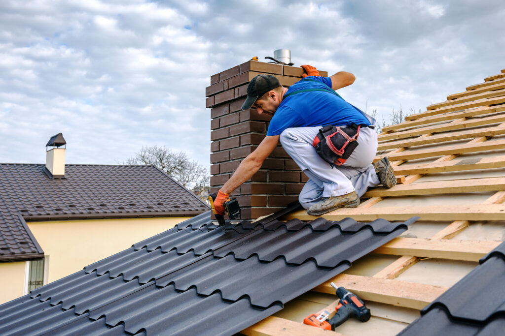 roofing companies yukon ok a professional master (roofer) with electric screwdriver covers repairs the roof