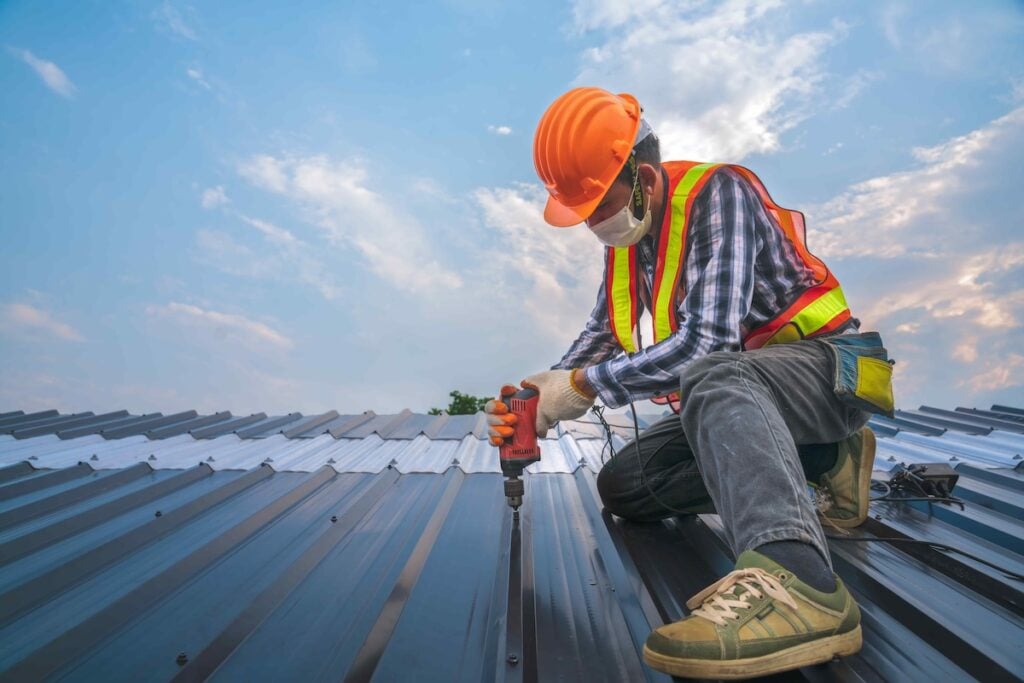 roofing companies Bethany ok Expertise construction worker wear safety uniform install new metal roofing work for roof ,worker roofer builder working on roof structure on construction site, industrial concept with copy space