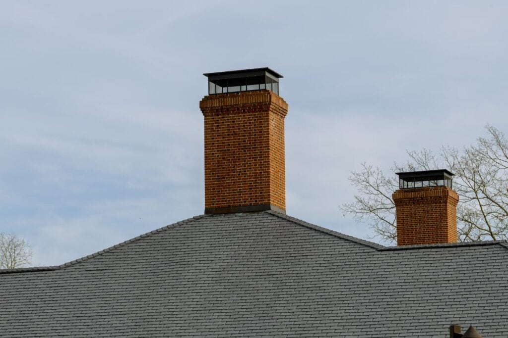 two chimney caps big house orange bricks grey roof