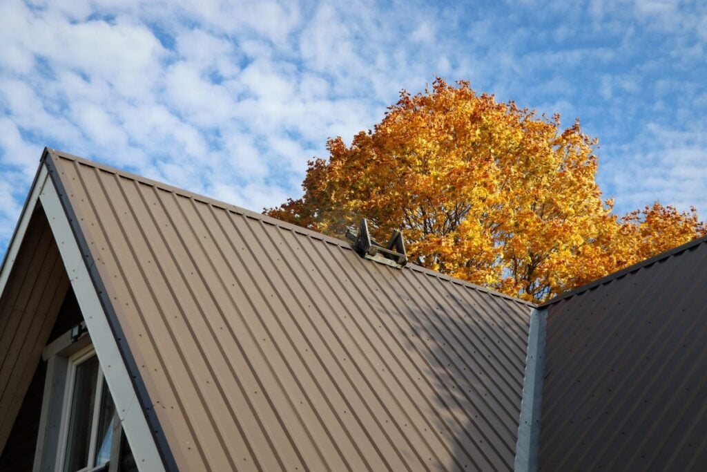 steep metal roof with a tree in the background