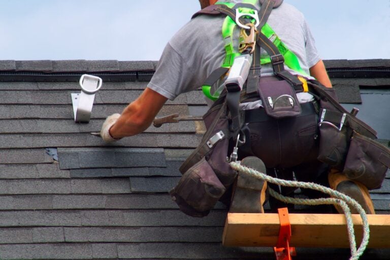 roofer repairing asphalt shingles
